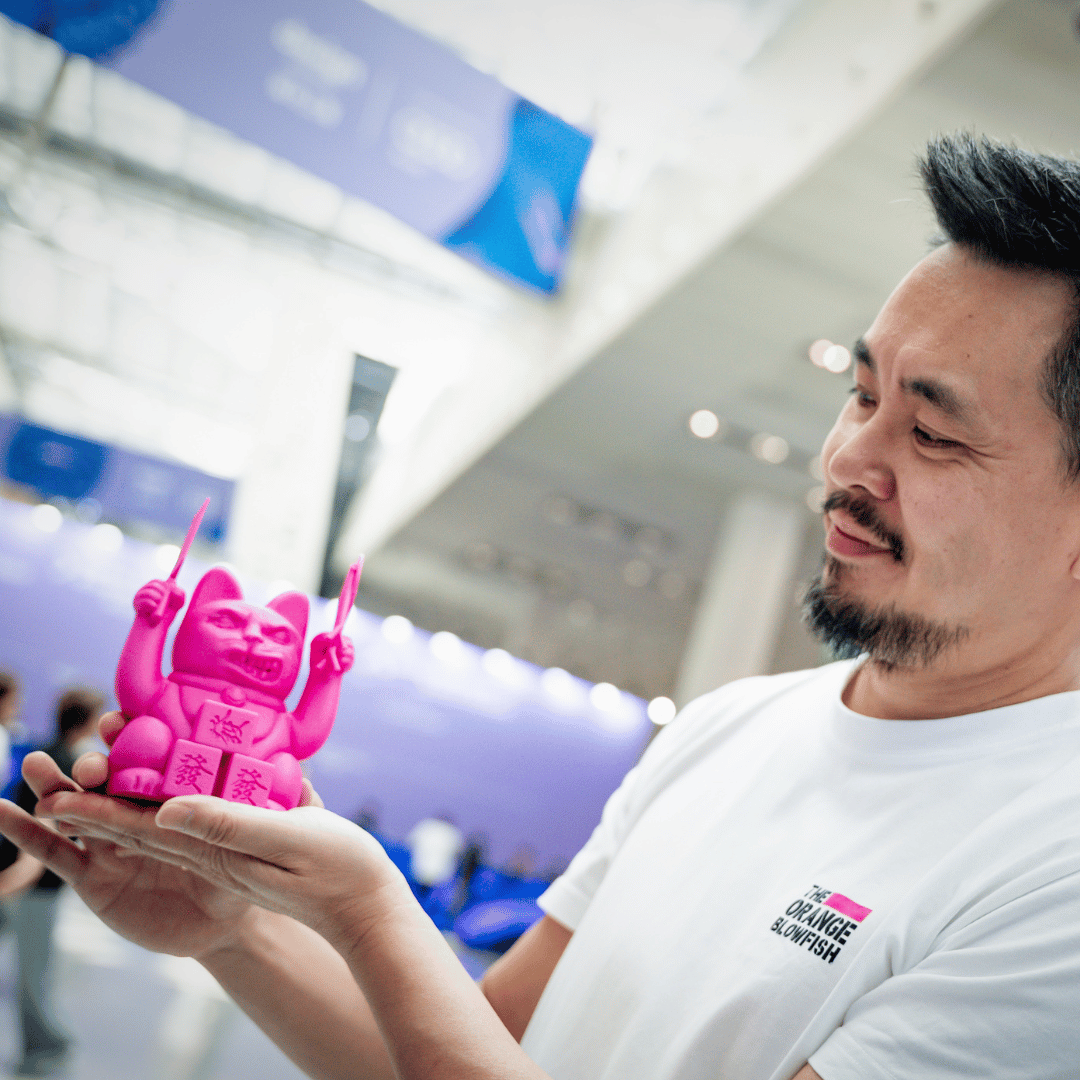 Siu Tang holding a 3D-printed Lucky Cat design on stage at Design Shanghai 2025